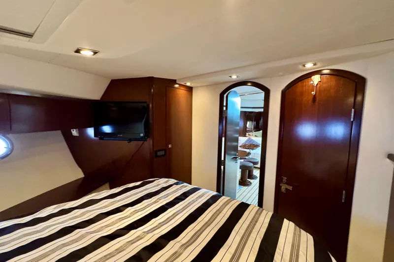  Yacht Photos Pics Luxurious interior of 2012 Cruisers Yachts 540 Sports Coupe with striped bedding and wood accents.