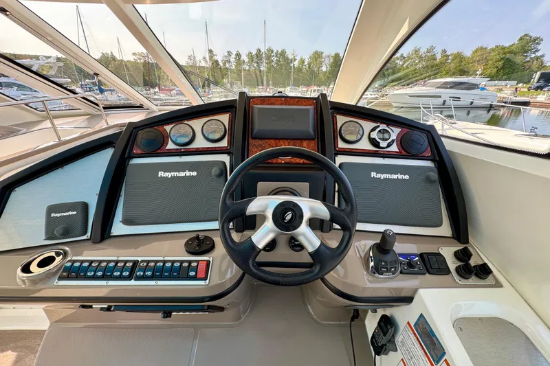  Yacht Photos Pics 2012 Cruisers Yachts 540 Sports Coupe helm with Raymarine navigation system and modern controls.