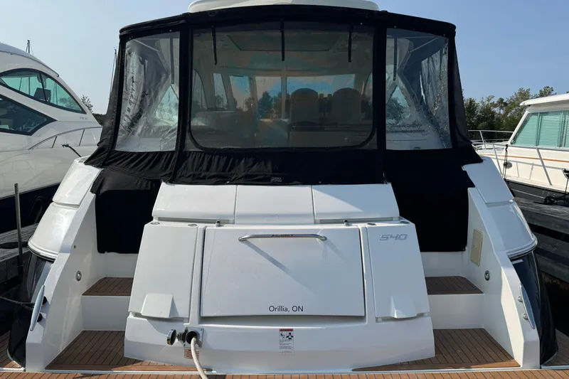  Yacht Photos Pics 2012 Cruisers Yachts 540 Sports Coupe docked, rear view with covered cockpit.