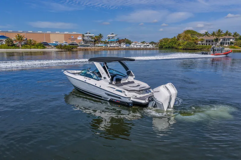  Yacht Photos Pics 2023 Monterey 305SS Super Sport boat cruising on a sunny day in a scenic marina.