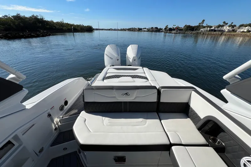  Yacht Photos Pics 2023 Monterey 305SS Super Sport boat with luxurious seating on a serene waterway.