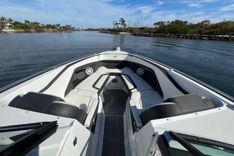  Yacht Photos Pics 2023 Monterey 305SS Super Sport boat interior on calm water, showcasing luxury seating.