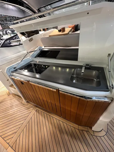  Yacht Photos Pics Modern yacht kitchen with stainless steel sink and stove, featuring wooden cabinetry. FIM 440 Regina 2025.