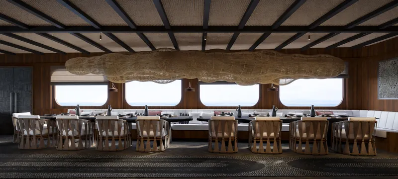 Jiva Ananta Yacht Photos Pics Luxurious dining area on 2027 Phinisi Custom yacht with elegant wooden decor and large windows.
