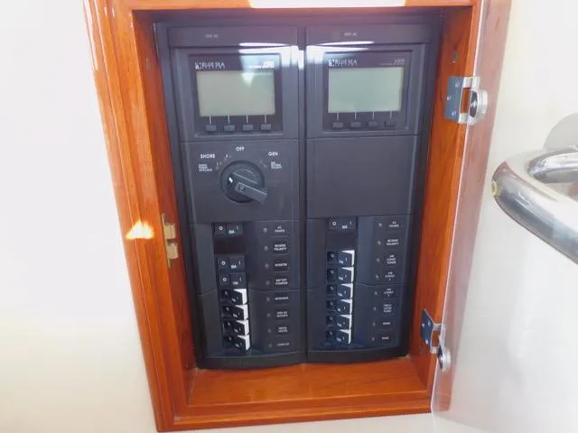  Yacht Photos Pics Hinckley T34 2013 electrical panel with switches and displays in wooden frame.