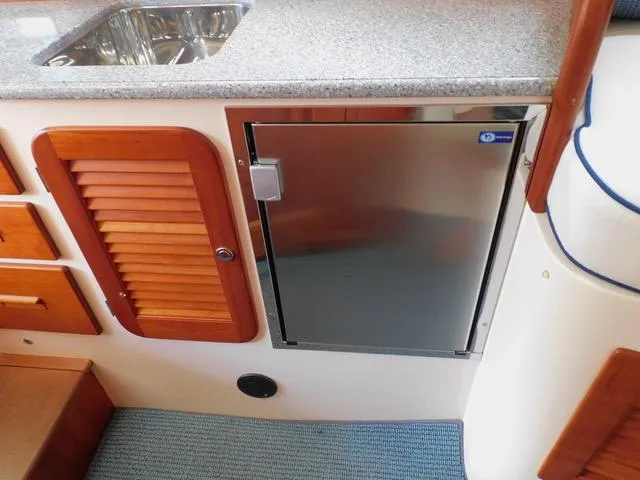  Yacht Photos Pics Hinckley T34 2013 yacht interior with stainless steel fridge and wooden cabinetry.