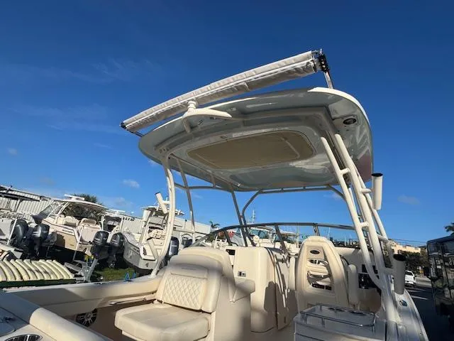  Yacht Photos Pics 2025 Grady-White Freedom 235 boat with seating and canopy under clear blue sky.