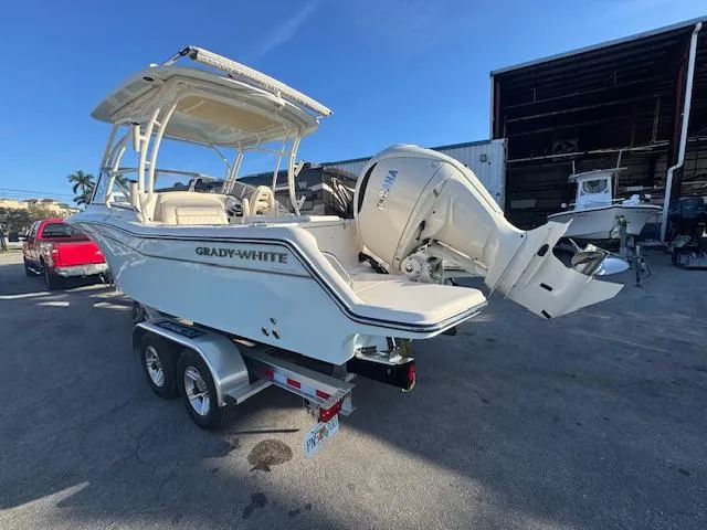  Yacht Photos Pics 2025 Grady-White Freedom 235 boat on trailer, parked outdoors, showcasing sleek design and powerful engine.