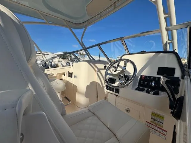  Yacht Photos Pics 2025 Grady-White Freedom 235 boat interior with steering wheel and seating.