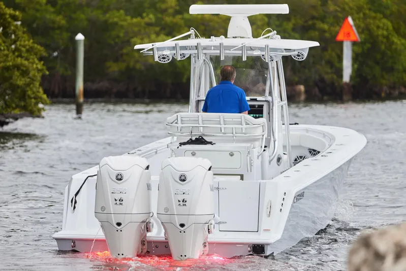  Yacht Photos Pics 2026 Contender 32 ST boat with dual outboard engines navigating through waterway.