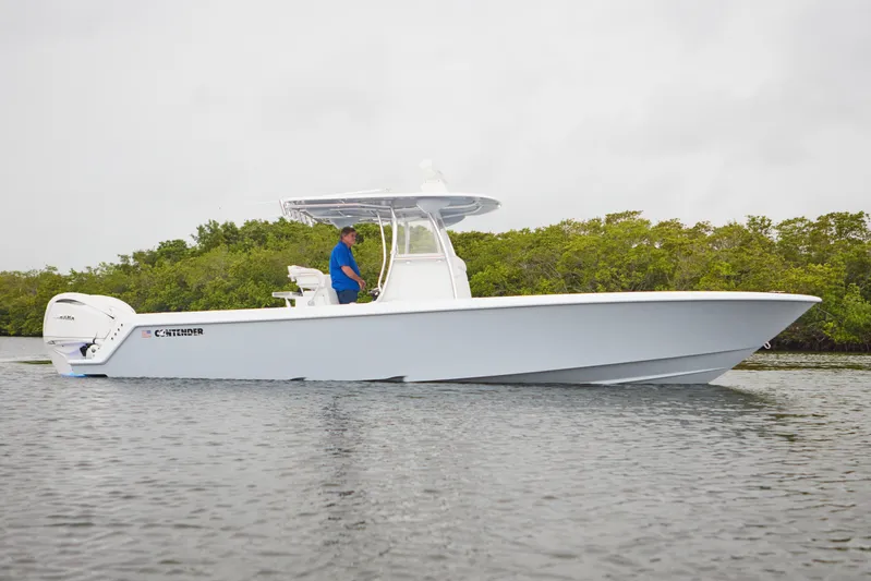  Yacht Photos Pics 2026 Contender 32 ST boat on water, side view, with lush greenery background.