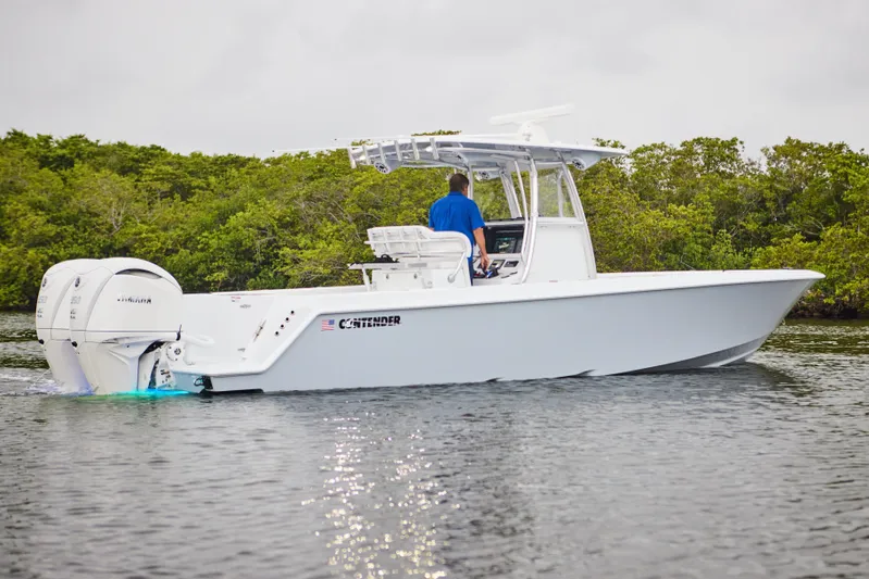  Yacht Photos Pics 2026 Contender 32 ST boat cruising on water with lush greenery in the background.