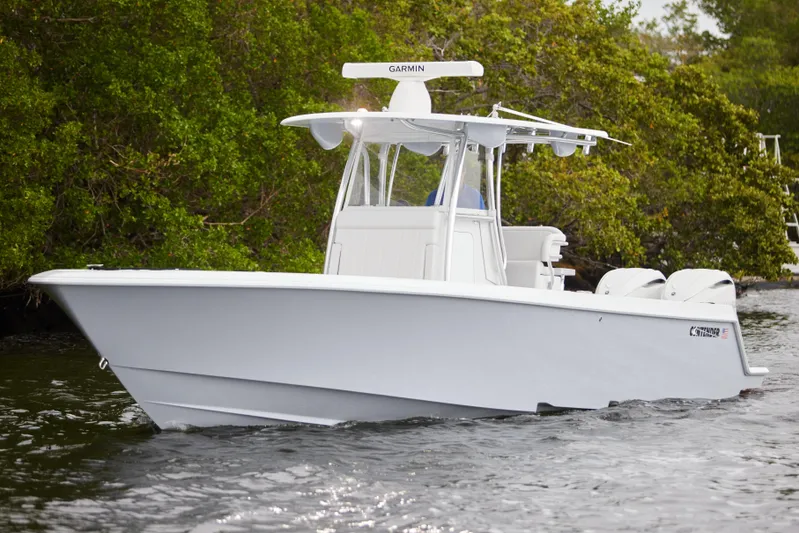  Yacht Photos Pics 2026 Contender 32 ST boat cruising on water near lush greenery.