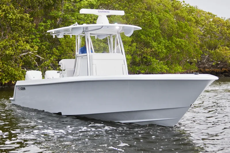  Yacht Photos Pics 2026 Contender 32 ST boat cruising on water near lush greenery.