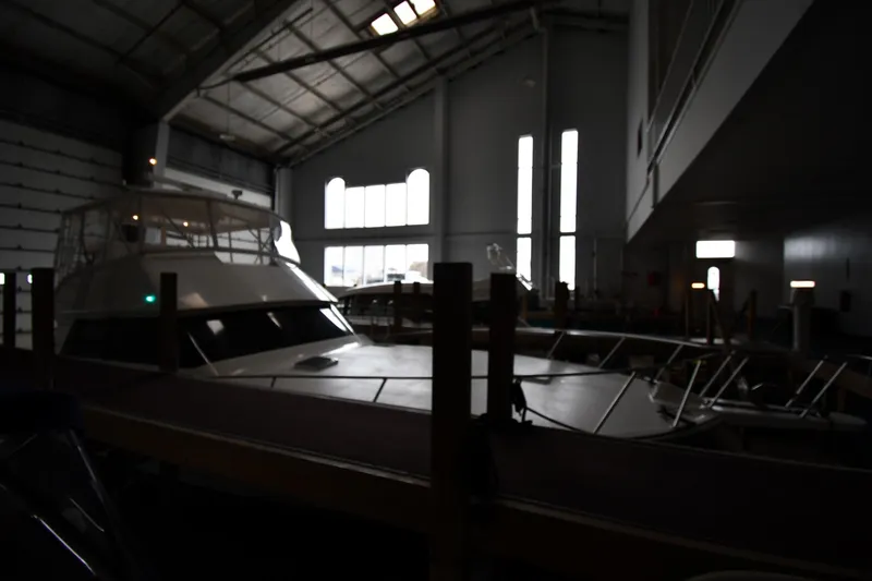 Your Rent's Due Yacht Photos Pics 1996 Viking 50 Convertible yacht in dimly lit indoor storage facility.