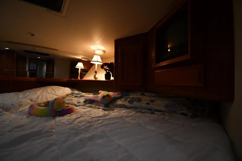 Your Rent's Due Yacht Photos Pics Cozy bedroom interior of 1996 Viking 50 Convertible yacht with soft lighting and plush bedding.