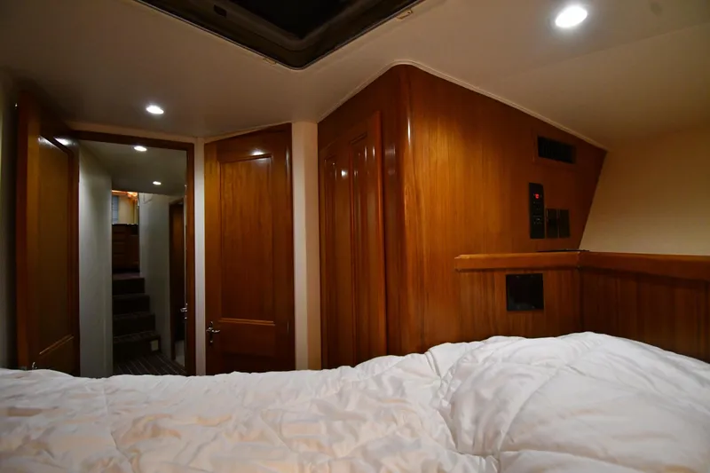 Your Rent's Due Yacht Photos Pics Cozy cabin interior of 1996 Viking 50 Convertible yacht with wood paneling and soft lighting.
