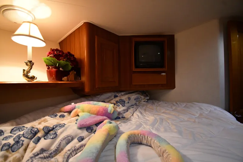 Your Rent's Due Yacht Photos Pics Cozy bedroom in 1996 Viking 50 Convertible yacht with plush toys and vintage TV.
