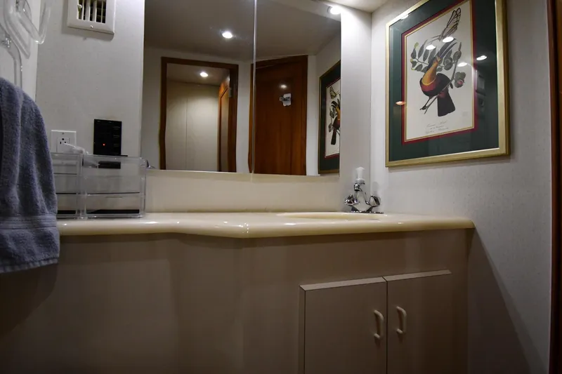 Your Rent's Due Yacht Photos Pics Bathroom interior of 1996 Viking 50 Convertible yacht with artwork and modern fixtures.