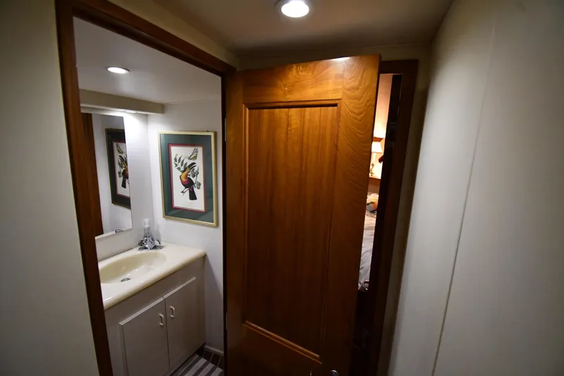 Your Rent's Due Yacht Photos Pics Bathroom interior of 1996 Viking 50 Convertible yacht with wooden door and framed artwork.