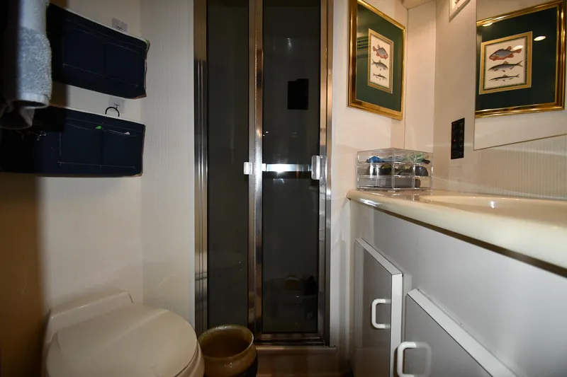 Your Rent's Due Yacht Photos Pics Bathroom interior of 1996 Viking 50 Convertible yacht with shower and framed fish art.