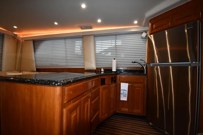 Your Rent's Due Yacht Photos Pics Luxurious kitchen interior of 1996 Viking 50 Convertible yacht with wood cabinetry and stainless steel appliances.