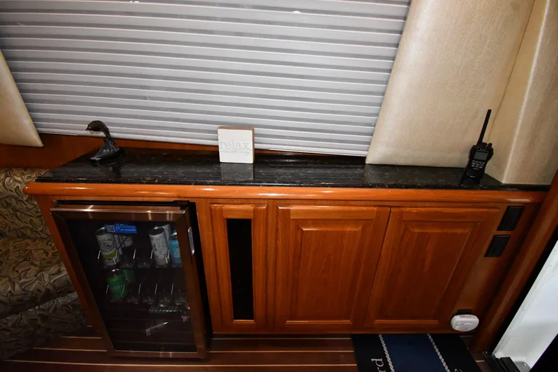 Your Rent's Due Yacht Photos Pics 1996 Viking 50 Convertible yacht interior with minibar, wooden cabinetry, and decorative accents.