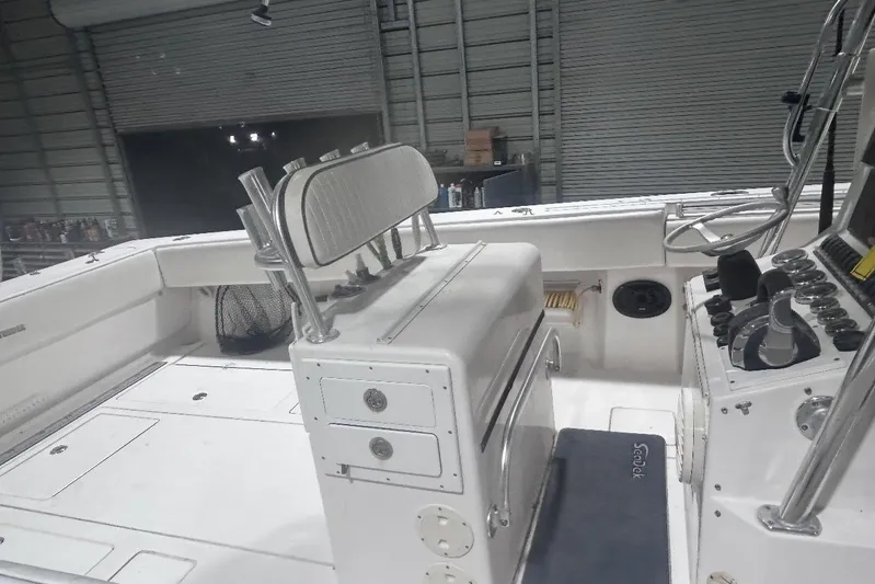  Yacht Photos Pics 2005 Contender 35 ST boat interior with helm, seating, and storage compartments in a garage.