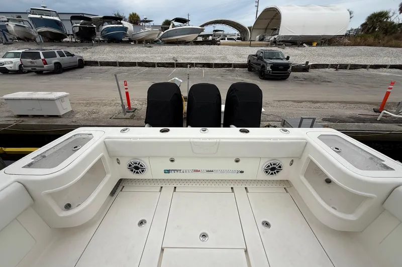  Yacht Photos Pics 2022 SeaVee 270Z boat with covered engines, docked near parked vehicles and other boats.