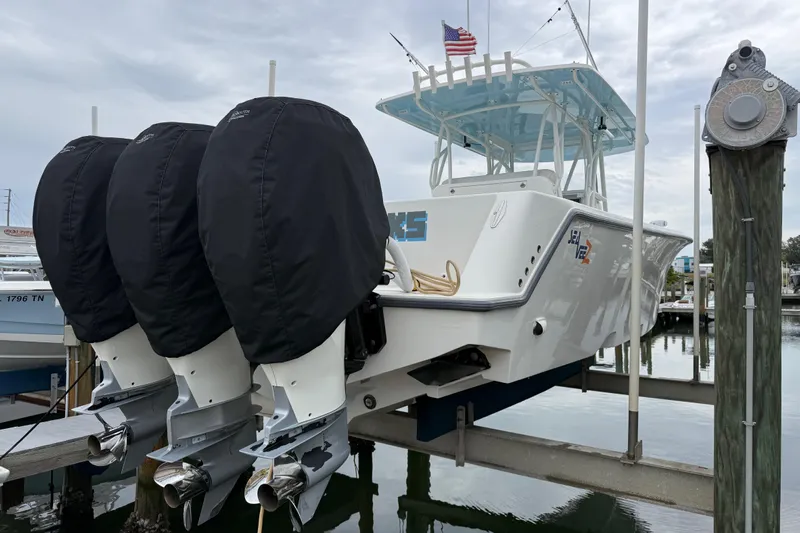  Yacht Photos Pics 2022 SeaVee 270Z boat with triple outboard engines on a lift, docked at a marina.