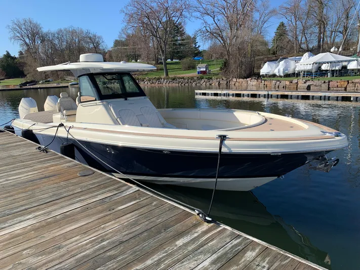  Yacht Photos Pics 2024 Chris-Craft Catalina 34 boat docked on a calm lake with trees in the background.