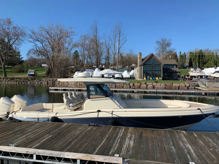  Yacht Photos Pics 2024 Chris-Craft Catalina 34 boat docked by a scenic waterfront.