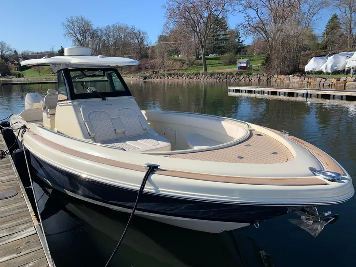  Yacht Photos Pics 2024 Chris-Craft Catalina 34 boat docked on a calm lake, showcasing sleek design and luxury features.