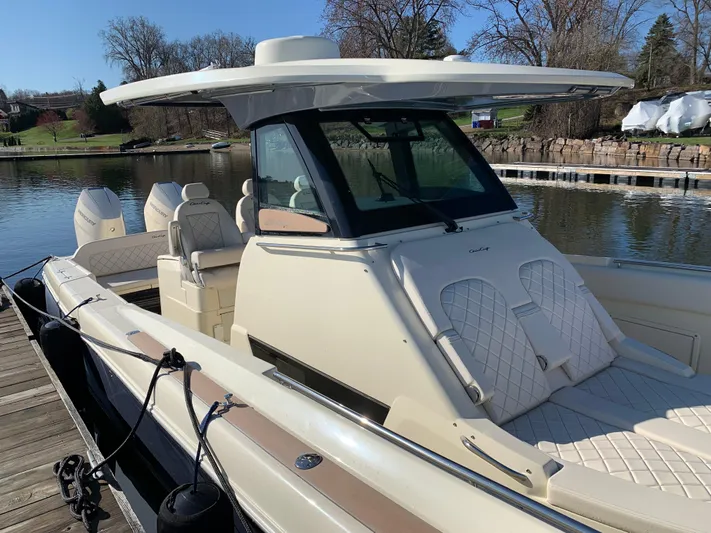  Yacht Photos Pics 2024 Chris-Craft Catalina 34 boat docked by a serene waterfront.