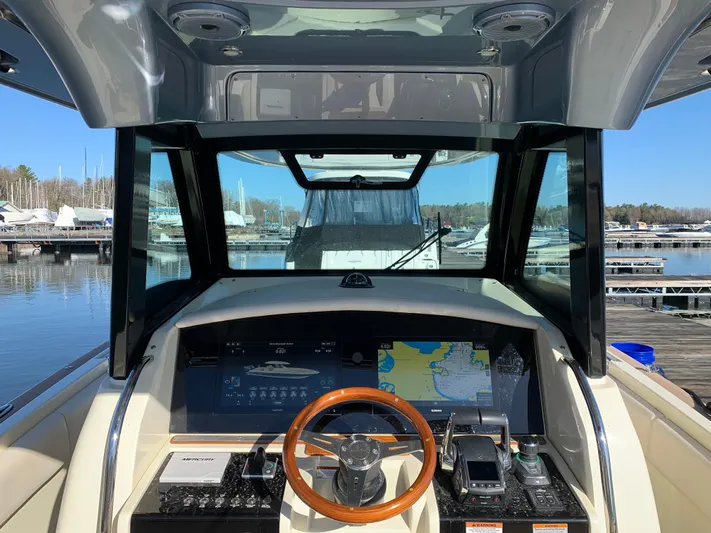  Yacht Photos Pics 2024 Chris-Craft Catalina 34 helm with navigation display and wooden steering wheel at marina.