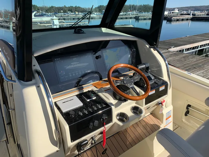  Yacht Photos Pics 2024 Chris-Craft Catalina 34 helm with wooden steering wheel and modern navigation displays.