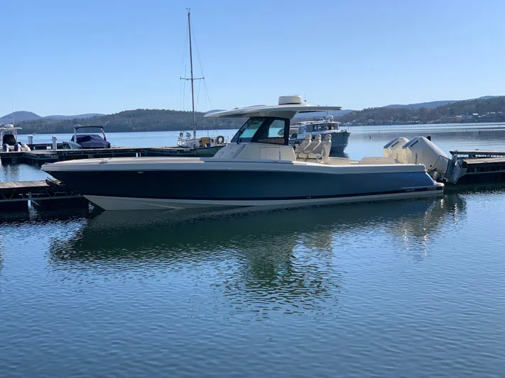  Yacht Photos Pics 2024 Chris-Craft Catalina 34 boat docked on calm water with scenic background.