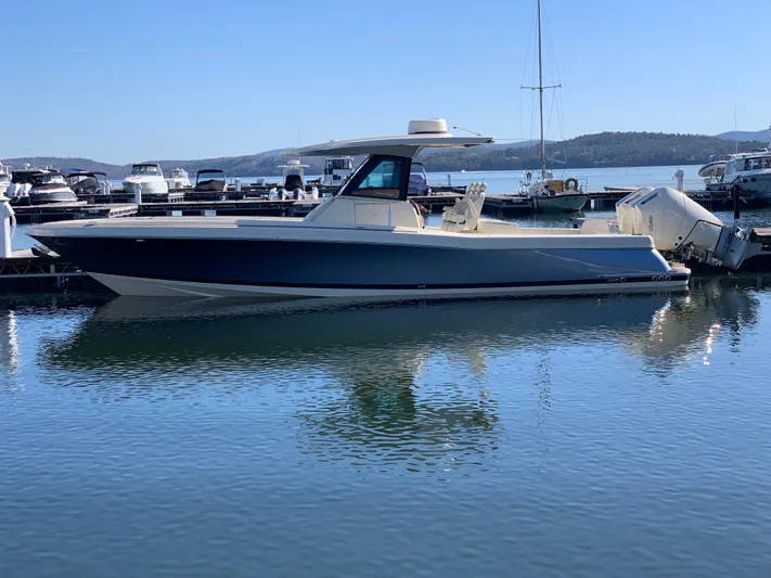  Yacht Photos Pics 2024 Chris-Craft Catalina 34 boat docked in a marina, calm water reflecting its sleek design.