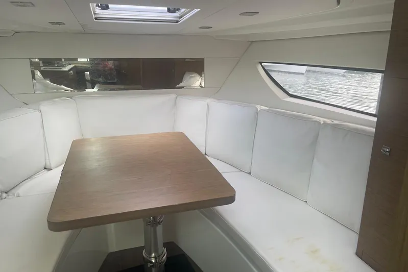 Mv Splash Yacht Photos Pics Interior of 2017 Jeanneau Cap Camarat 10.5 with white seating and wooden table.