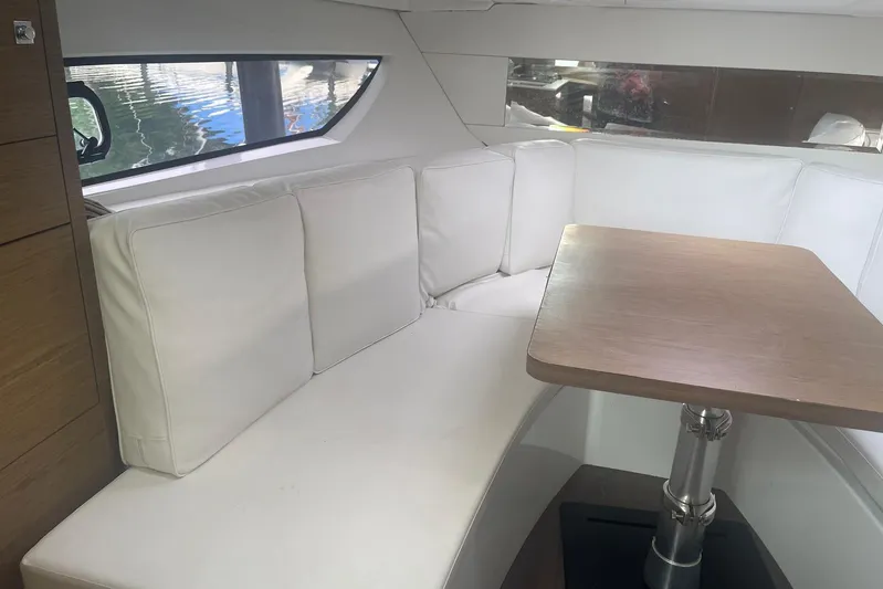 Mv Splash Yacht Photos Pics Interior of 2017 Jeanneau Cap Camarat 10.5 with white seating and wooden table.