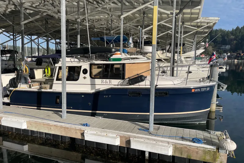  Yacht Photos Pics 2019 Ranger Tugs R-27 boat docked in a marina under a covered structure.
