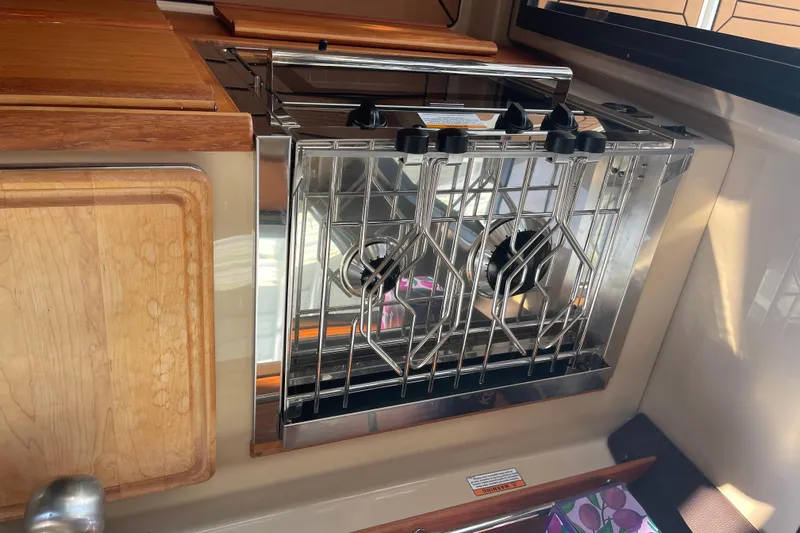  Yacht Photos Pics 2019 Ranger Tugs R-27 interior kitchen with stove and wooden cabinetry.