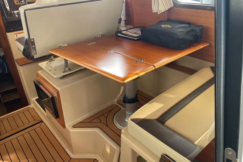  Yacht Photos Pics 2019 Ranger Tugs R-27 interior with wooden table and cushioned seating.
