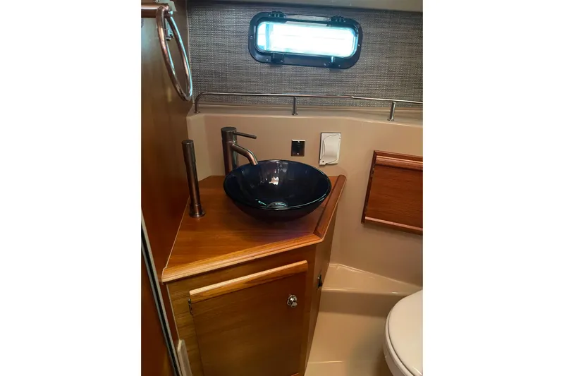  Yacht Photos Pics 2019 Ranger Tugs R-27 bathroom with modern sink and wooden cabinetry.