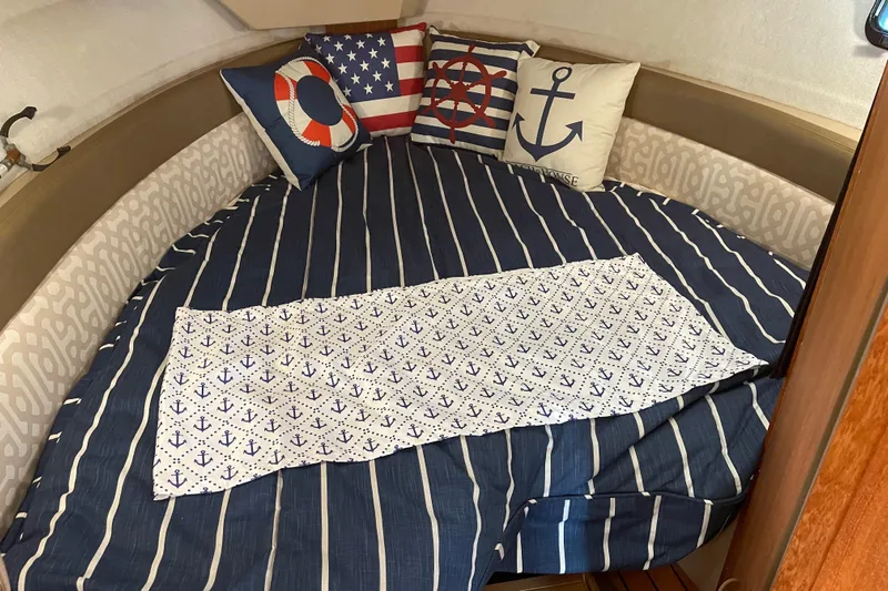  Yacht Photos Pics Cozy cabin interior of 2019 Ranger Tugs R-27 with nautical-themed bedding and pillows.