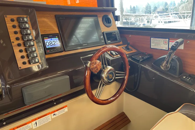  Yacht Photos Pics 2019 Ranger Tugs R-27 helm with wooden steering wheel and modern navigation equipment.