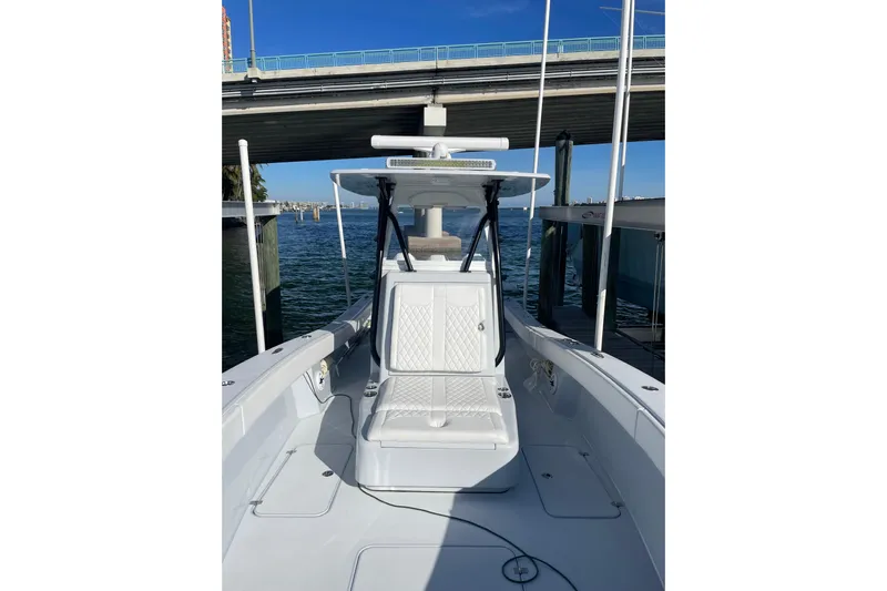  Yacht Photos Pics 2022 Conch 33 boat docked under a bridge, featuring sleek white seating.