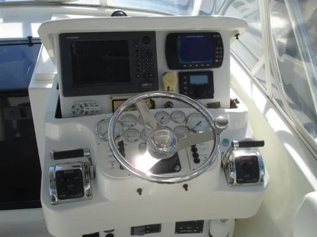 Bait's Factor Yacht Photos Pics Control panel of a 2002 Stolper 35 EXPRESS boat with steering wheel and navigation instruments.