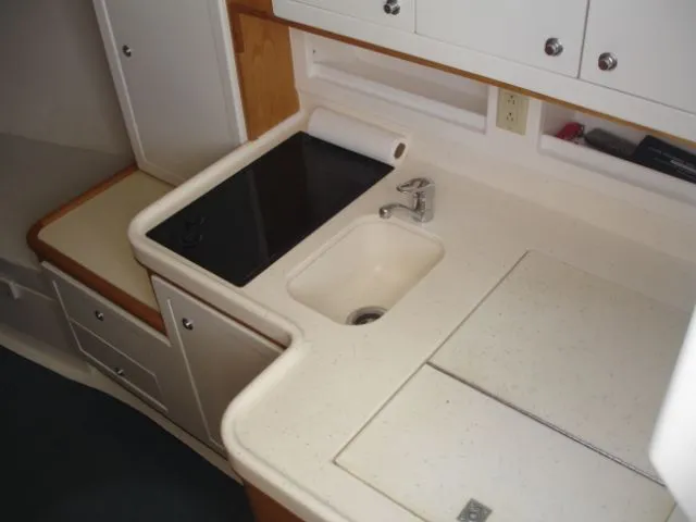 Bait's Factor Yacht Photos Pics Compact kitchen area in a 2002 Stolper 35 EXPRESS boat, featuring a sink and stovetop.