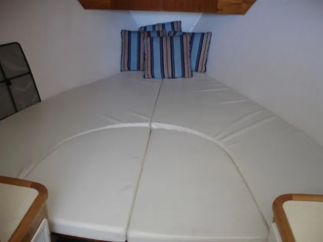 Bait's Factor Yacht Photos Pics Interior cabin of 2002 Stolper 35 EXPRESS with striped cushions and white bedding.